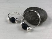 Creole earrings featuring black stone beads and silver donuts